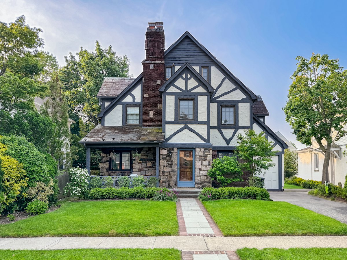 Tudor Revival home with a manicured front lawn